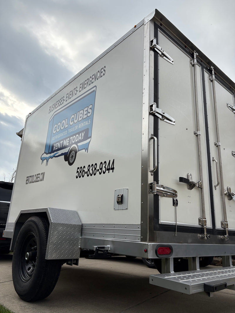 Reefer trailer rental by Cool Cubes at outdoor wedding reception under string lights, keeping food and beverages perfectly chilled for events, emergencies, and businesses. Portable refrigerated trailer with Thermo King unit, ideal for catering and event cooling. Call 586-838-9344 or visit rentcoolcubes.com.